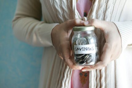 woman holding savings jar / retirement myths
