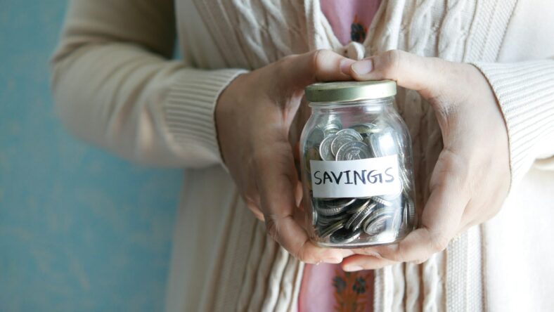 woman holding savings jar / retirement myths