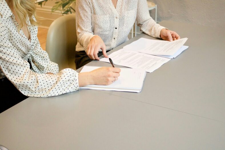 women sitting with paperwork