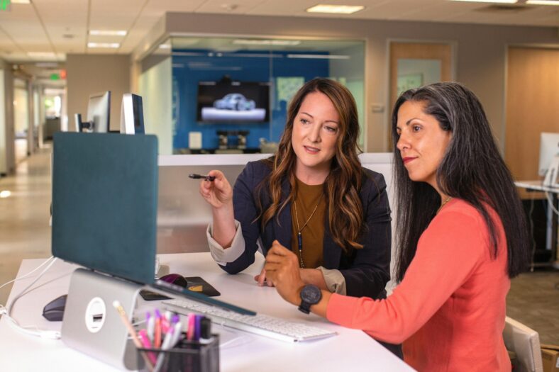 two women pointing at screen / small businesses